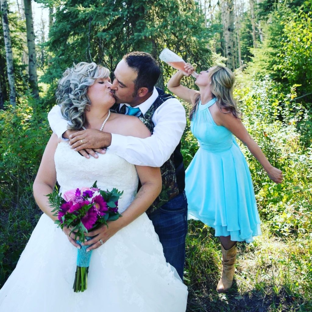 A wedding couple kissing while on a wine tour in Lake Country